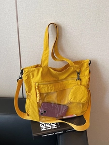 Large yellow nylon tote bag with transparent front pocket and adjustable shoulder strap