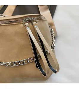 Detail of khaki leather bag with smooth dual silver zippers and long leather pullers