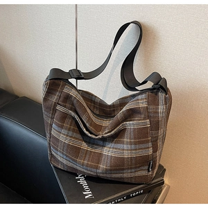 Dettaglio della borsa vintage a quadri con tracolla regolabile e chiusura a zip nera