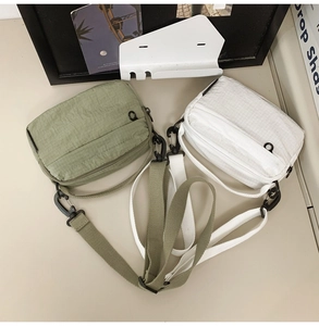 Detail showing checkered nylon crossbody bags with adjustable straps and black hooks