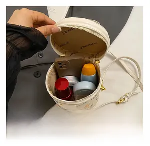 Internal view of the cream bucket bag showing space for phone, lipstick and cosmetics