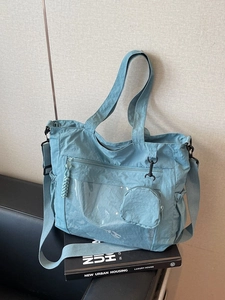 Light blue nylon tote bag with multi-pockets and adjustable strap for urban styling