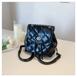 Detail of black quilted PU leather backpack with silver twist lock and drawstring