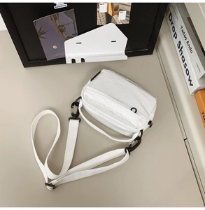 Close-up of white grid nylon crossbody bag with durable black hardware and minimalist design