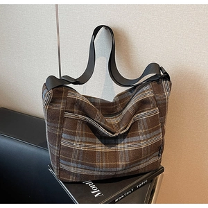 Dettaglio borsa tote vintage a quadri marroni con tracolla larga e trama in tweed