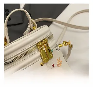 Close-up of golden dual-zipper and graffiti bucket bag with polished hardware detail
