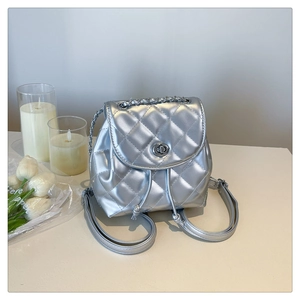 Detail shot of silver quilted mini backpack with twist lock and metal chain handle