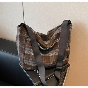 Dettaglio della borsa Hobo a scacchi marroni con tracolla in nylon nero regolabile