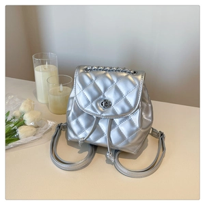Silver quilted chain backpack featuring metallic finish and metal turn-lock closure detail