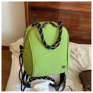 Close-up of fruit green nylon backpack featuring woven rope handles and metal logo detail