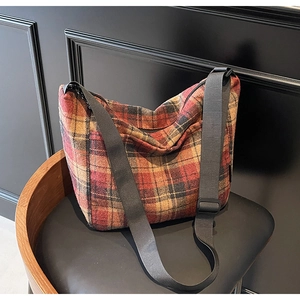 Dettaglio della trama a quadri vintage e della tracolla in nylon sulla borsa tote retrò