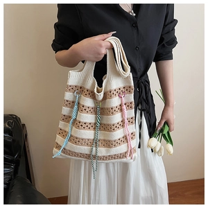 Detail of hand-woven striped knit tote bag featuring colorful boho knots and soft texture