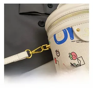 Detail of lychee pattern leather bucket bag featuring blue graffiti and gold metal hook