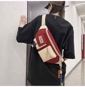 Détail du sac à bandoulière rouge et blanc à poches multiples avec chaîne décorative