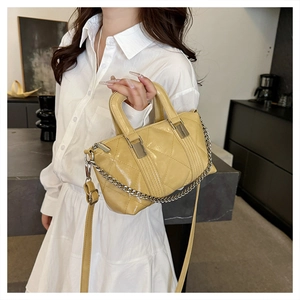 Detail showing the quilted faux leather texture and silver chain strap of the crossbody bag