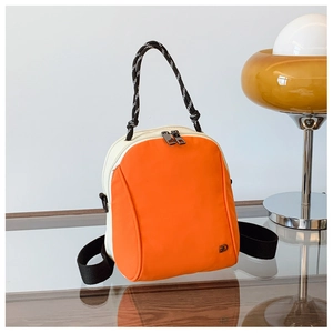 Detail view of stylish orange and white mini backpack with woven handle and dual zippers
