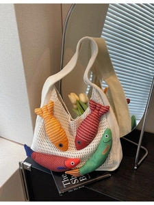 Chic beige crochet tote bag featuring colorful fish patches and a casual knit texture