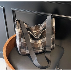 Dettaglio della borsa a tracolla vintage a quadri marrone e beige con cinturino regolabile
