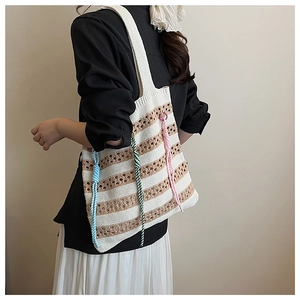 Close-up of knit hollow stripe tote bag with colorful twisted rope tassels and texture