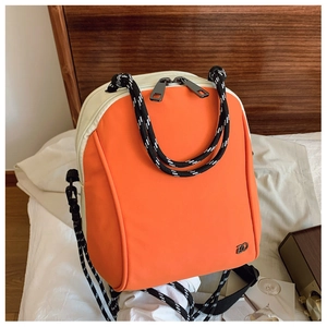 Detail view of the orange and beige contrasting color backpack with braided rope handle