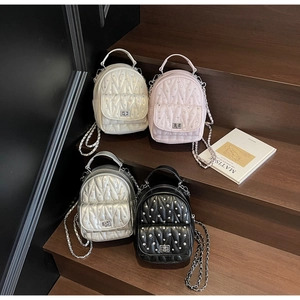 Close-up of quilted leather mini bags with metal turn-lock and elegant chain straps