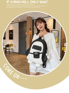 Detail eines süßen Pinguin-Leinenrucksacks mit Schwarz-Weiß-Kontrast und Plüschball-Anhänger