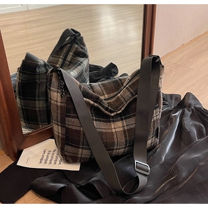 Dettaglio borsa vintage in tela scozzese con tracolla larga e fibbia in metallo