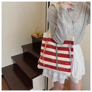 Detail of red and white striped knitted tote bag with colorful decorative tassels