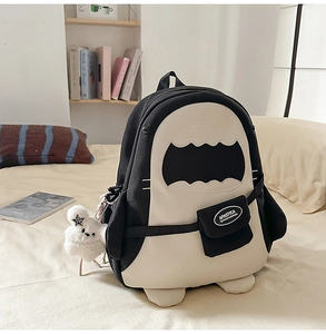 Detail eines Kontrast-Rucksacks für Studenten mit süßem Plüschtier auf einem Bett