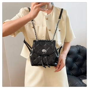 Quilted black mini backpack with silver chain straps shown on a model in high-end style