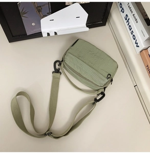 Detail view of the durable green ripstop crossbody bag with an adjustable strap