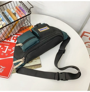 Détail du sac de poitrine en nylon à plusieurs poches noir et vert avec sangle