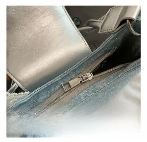 Détail du sac en jean bleu avec strass brillants et fermeture magnétique argentée