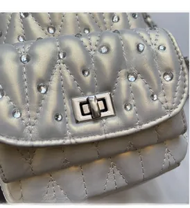 Macro shot of silver quilted leather with rhinestones and metal turn-lock buckle