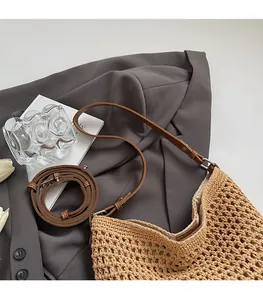 Detail of adjustable leather strap and bohemian woven texture on a straw crossbody bag