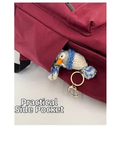 Close-up of practical side pocket on burgundy backpack with knitted owl charm attached