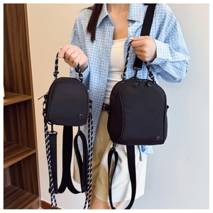 Detail showing two sizes of black nylon backpacks with unique striped rope handles