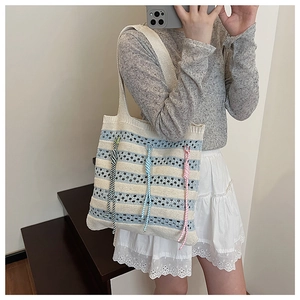 Detail of hollow knit texture on blue and white striped oversized beach tote bag