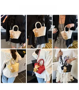 Détail de sacs seaux tressés en plusieurs couleurs avec des breloques d'ours mignonnes