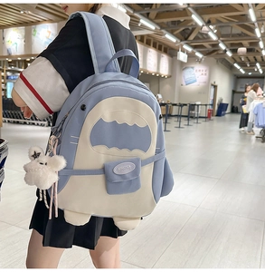 Detail eines Schulrucksacks mit blauen Kontrasten und einem süßen weißen Plüschhasen