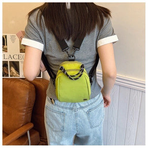 Fluorescent green mini nylon backpack shown as a stylish crossbody bag on a model