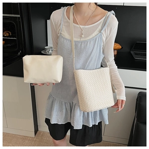 Détail du sac seau tissé blanc cassé et pochette en cuir avec bandoulière