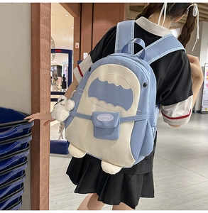 Schulrucksack im Haifisch-Design mit blau-weißen Nähten und weißem Bommelanhänger