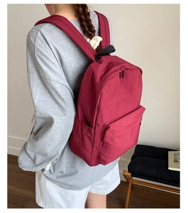 Deep red lightweight nylon backpack showing side profile and spacious storage compartments