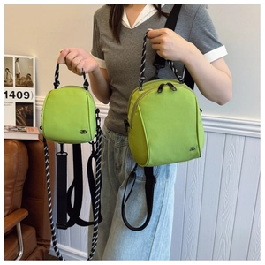 Detail view of light green commuter bags in two sizes with striped handles and metal logo