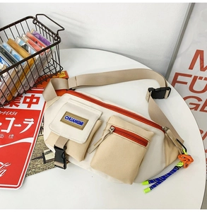 Détail du sac bandoulière tendance avec zips orange et sangle réglable sur fond blanc