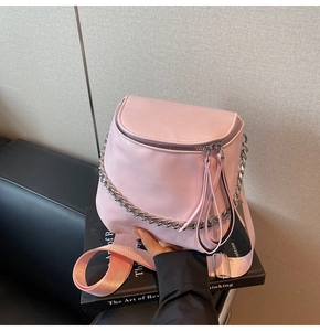 Detail of pink saddle bag with long leather tassels and chunky silver metal chain strap