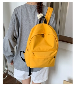 Detailed back view of a yellow lightweight backpack showing its large capacity and straps