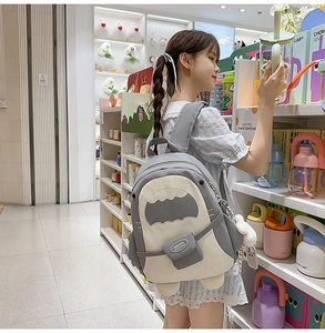Detailansicht eines Hai-Canvas-Rucksacks im Color-Block-Design mit niedlichem Plüsch-Anhänger