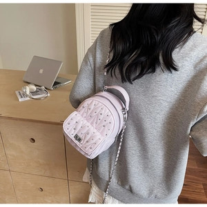 Close-up of pink quilted backpack with sparkling rhinestones and silver chain strap